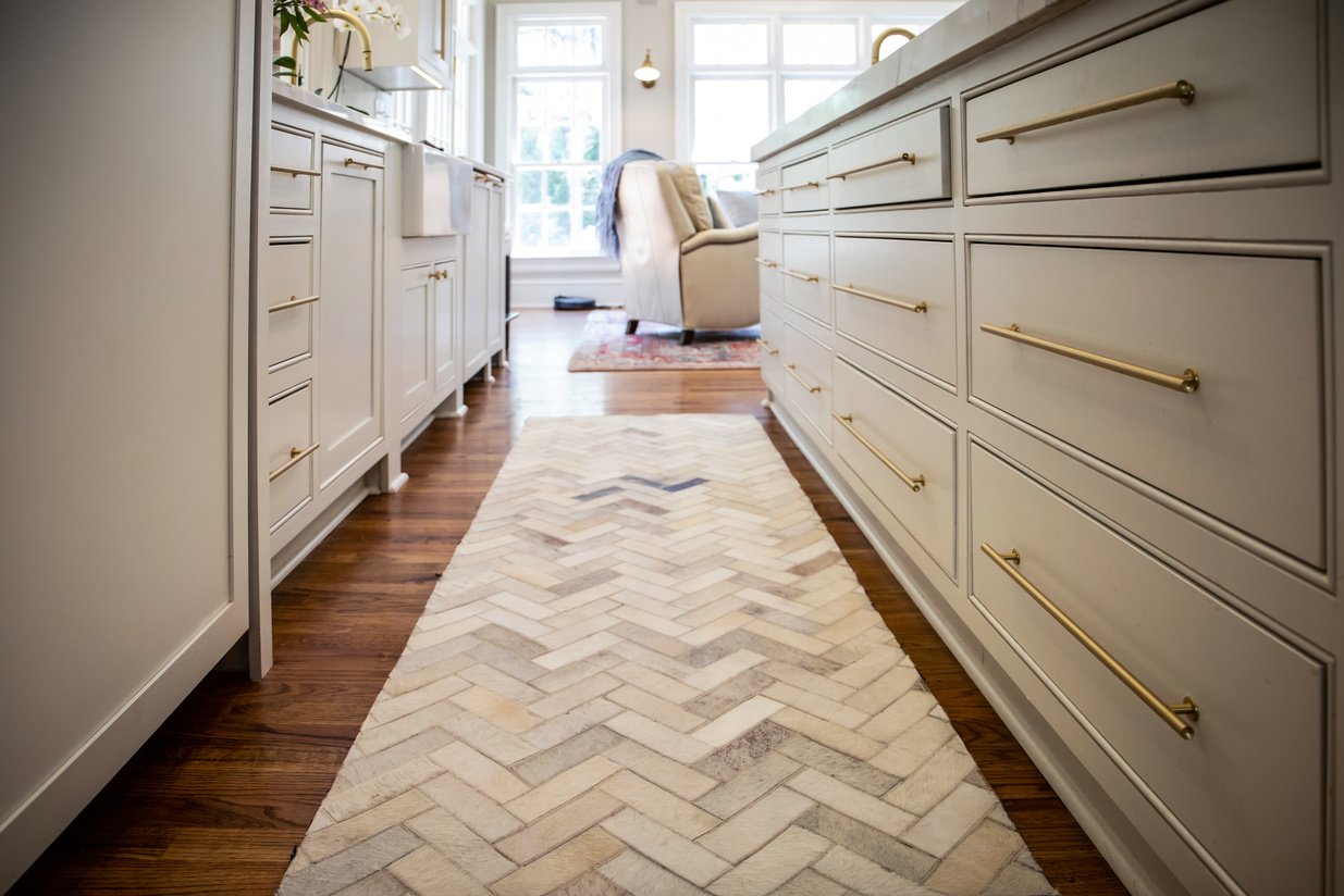 Lower view of kitchen hardwood floor with herringbone rug